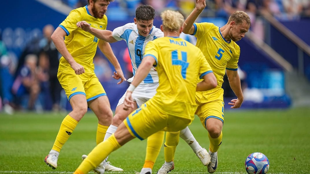 Хулиан Альварес из Аргентины ведет мяч против украинцев Валентина Рубчинского и Максима Таловерова во время Летних Олимпийских игр 2024 года