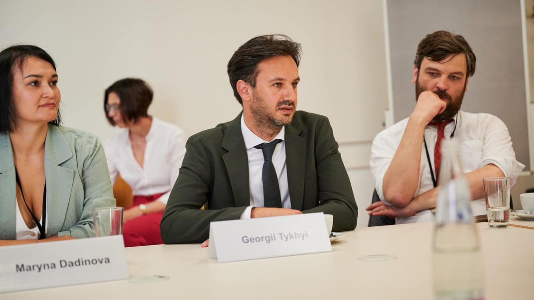 Георгій Тихий (у центрі) на семінарі в Німеччині, липень 2023 року. На той час він був радником із комунікацій міністра закордонних справ України Дмитра Кулеби