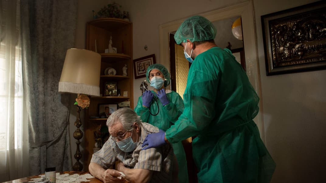 Медсестра надає допомогу пацієнту, хворому на COVID-19, під час візиту додому в Барселоні, Каталонія, північно-східна Іспанія, 23 травня 2020 року