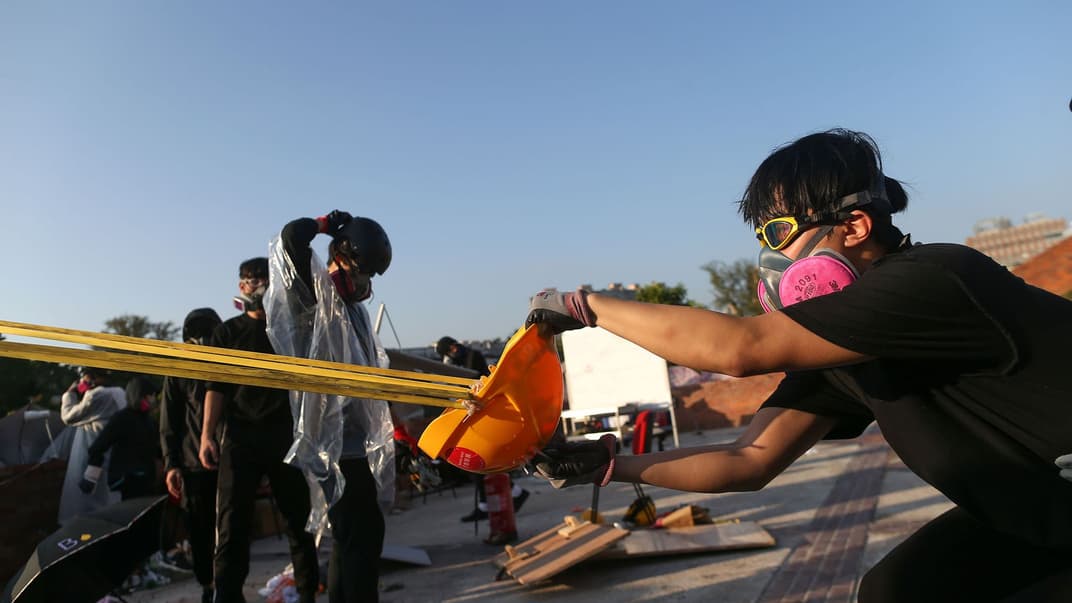 Протестувальники використовують гігантську рогатку проти поліції під час протистояння біля Гонконгського політехнічного університету, 17 листопада 2019 року