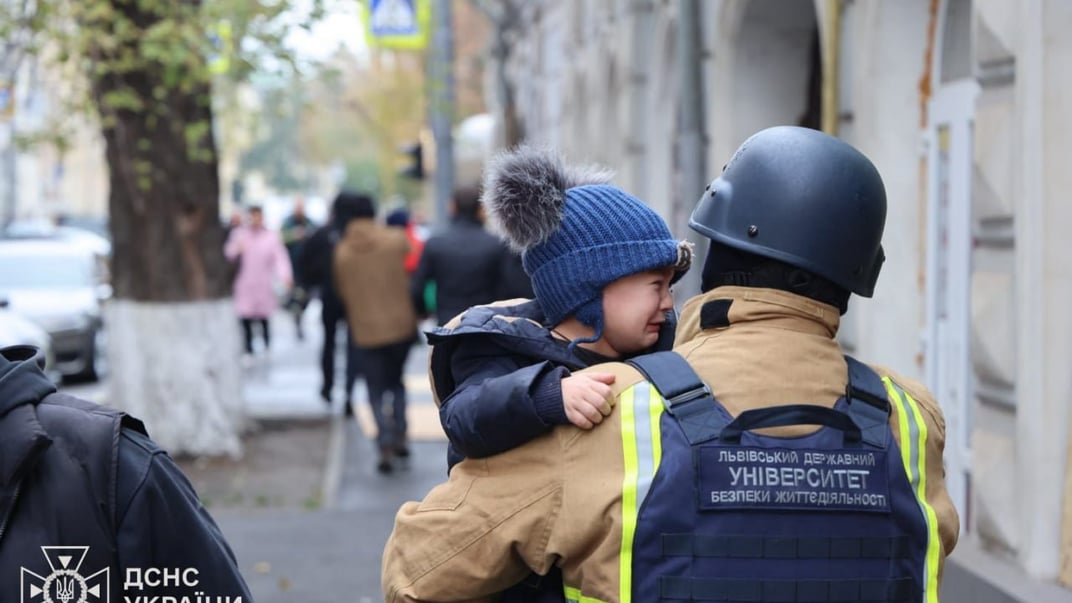Рятувальник несе дитину після російського удару по садочку у Харкові, 22 жовтня 2025 року