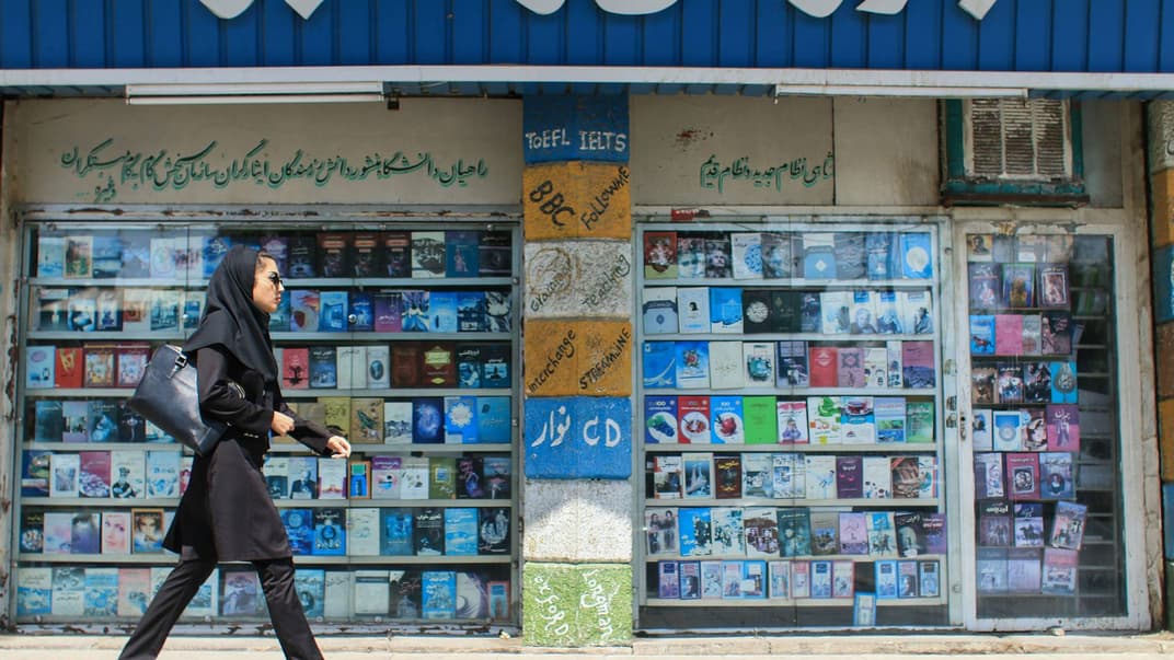 Іранська жінка проходить повз магазин компакт-дисків із фільмами у місті Шираз, Іран