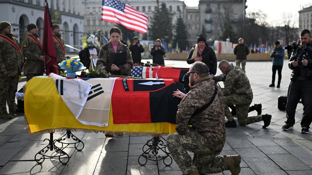 Військовослужбовці віддають шану біля труни загиблих південнокорейського та американського добровольців 2 Інтернаціонального легіону під час церемонії прощання на майдані Незалежності в Києві, 25 листопада 2025 року