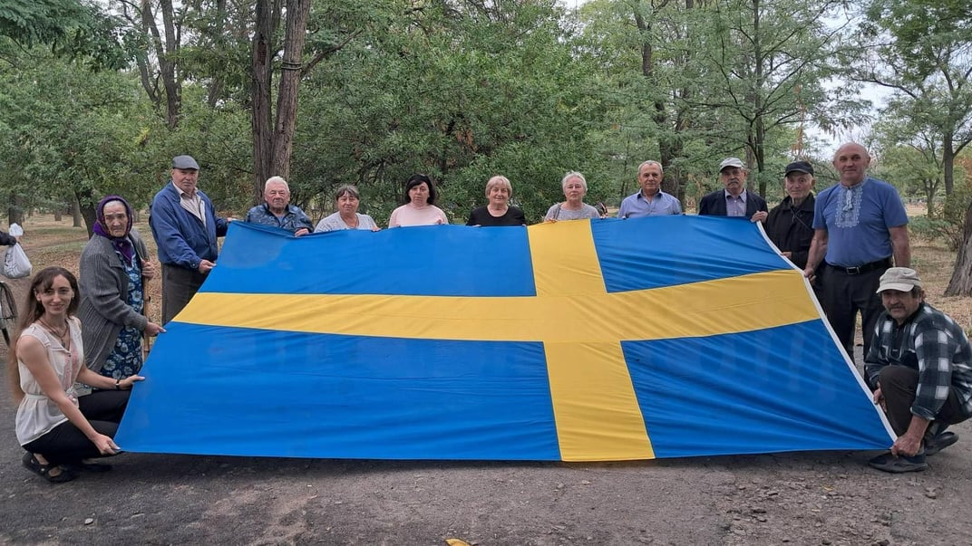 Мешканці Зміївки на Херсонщині з прапором Швецїі, який селу подарував сам король Швеції у 2008 році