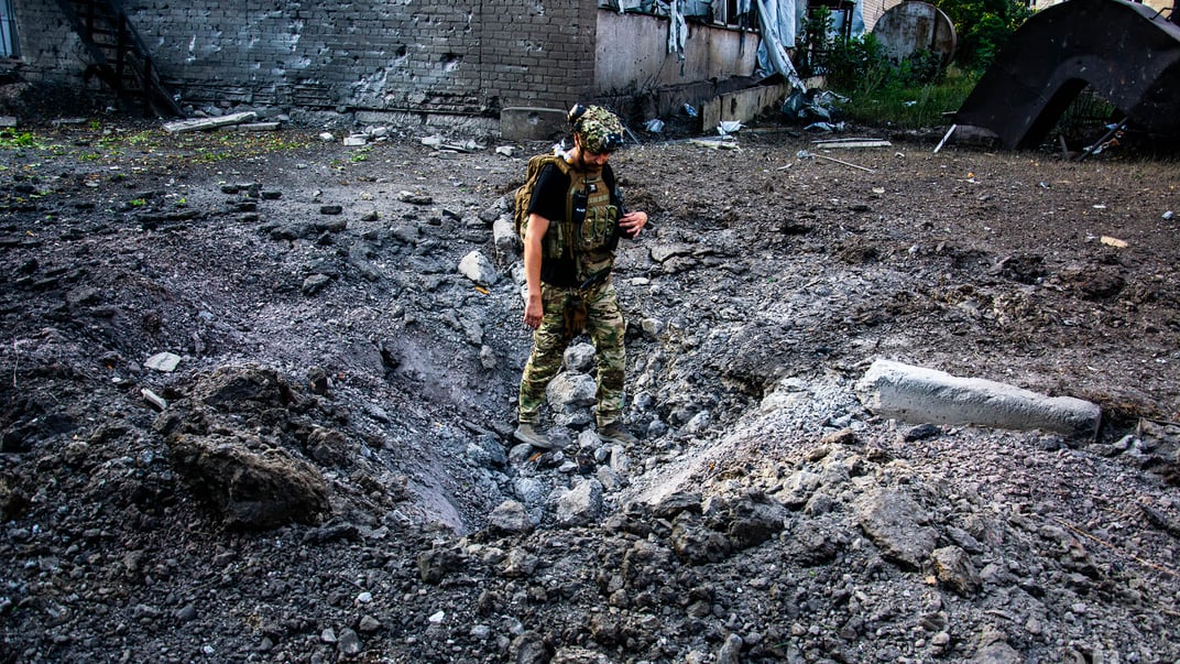 Український військовий у вирві від розірваного снаряда