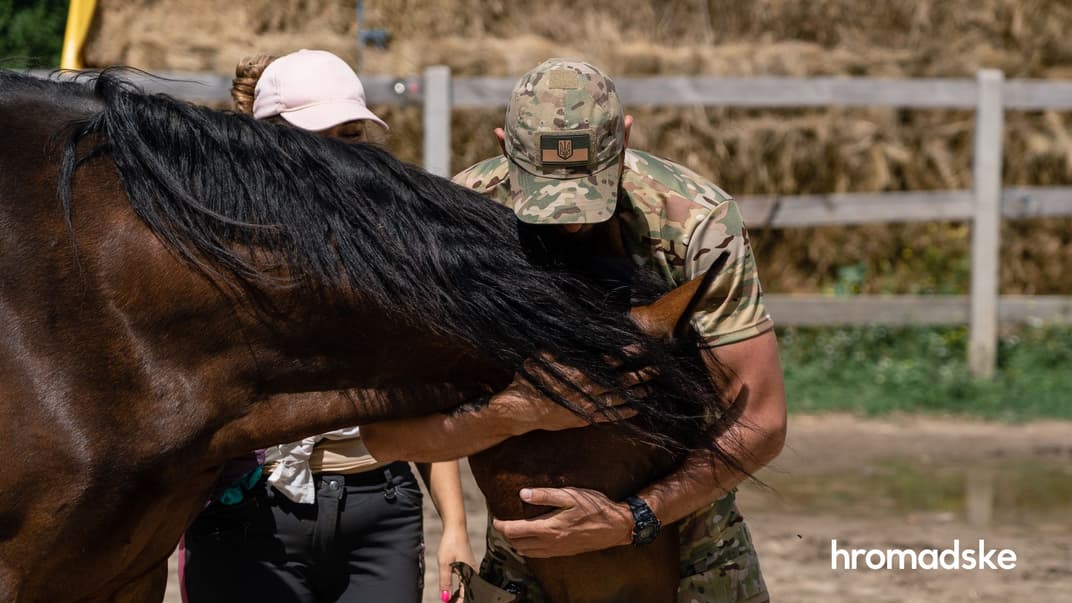 Военный обнимает коня на занятии по иповенции на конюшне в поселке Коротич под Харьковом
