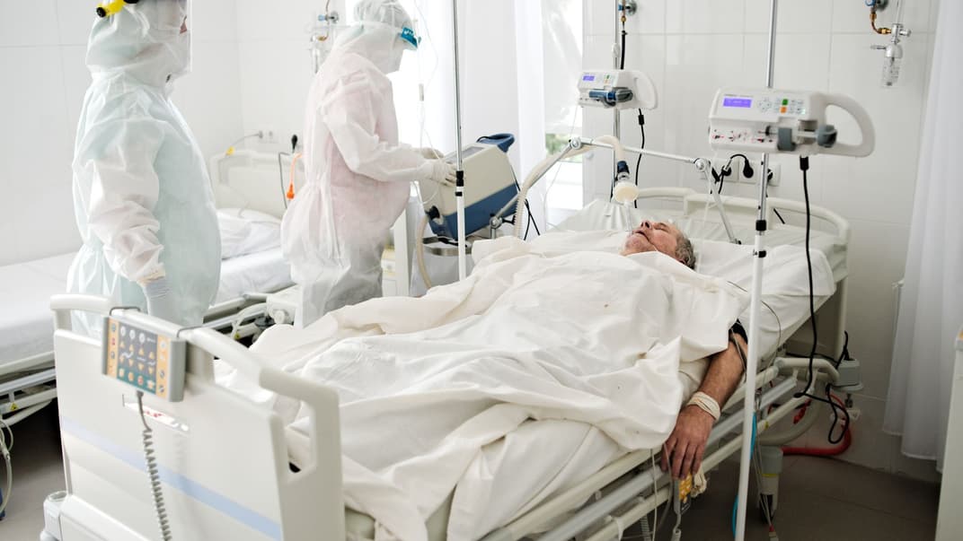 Лікарі обстежують людину, хвору на коронавірус, у палаті інфекційного відділення лікарні в Харкові