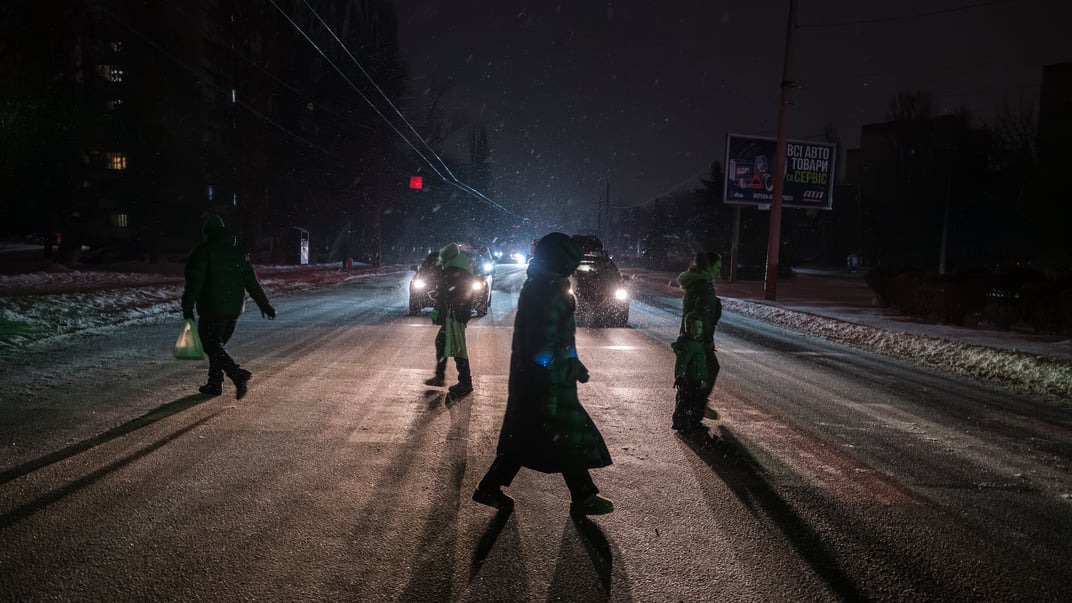 Люди переходять вулицю під час відключення електроенергії, спричиненого нещодавніми російськими ракетними та дронними атаками на критичну цивільну інфраструктуру, Київ, Україна, 11 січня 2026 року