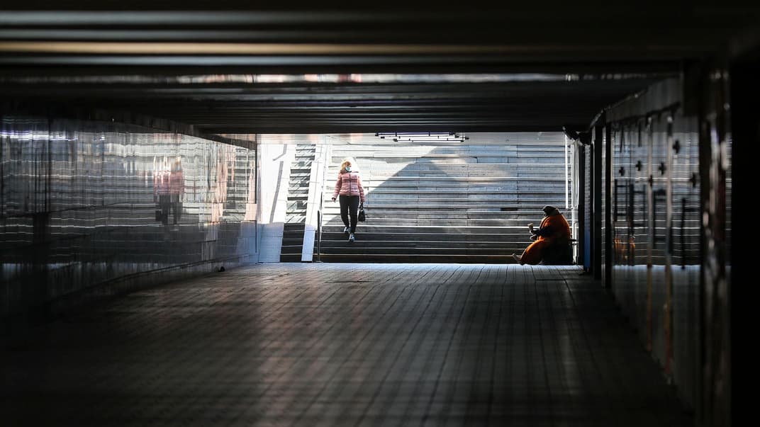 Літня безпритульна жінка просить гроші у майже безлюдному через карантин підземному переході у Києві, 23 березня 2020 року