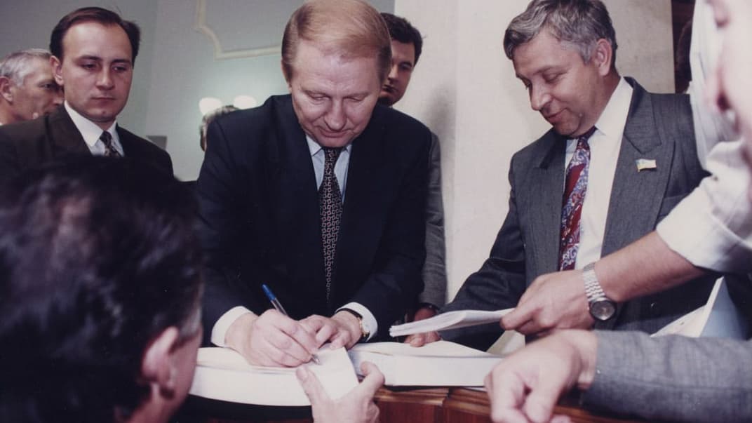 Президент України Леонід Кучма ставить автограф на примірнику щойно ухваленої Конституції України, 28 червня 1996 року.