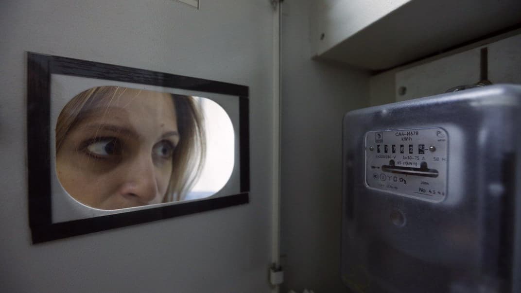 Женщина смотрит на счетчик электроэнерги, Киев, 30 августа 2016 года