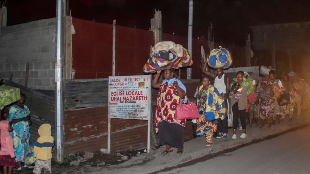 Люди втікають зі своїми речами під час виверження вулкана Ньїрагонго в Гомі, 22 травня 2021 року