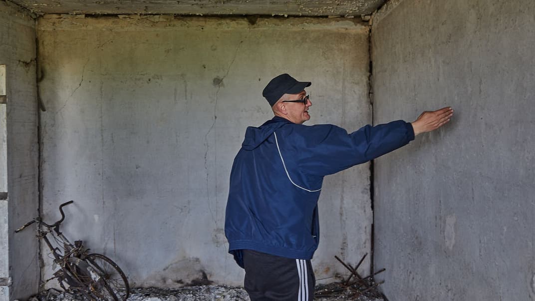 Родіон показує тріщини на несучих стінах своєї квартири, повністю знищеної внаслідок влучання снаряда