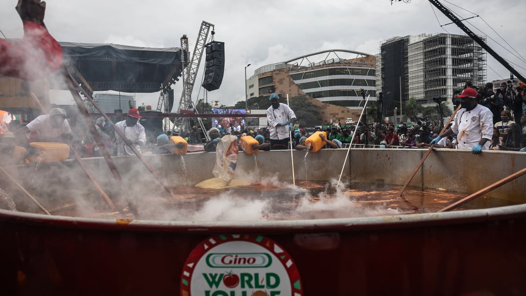 Кухарі помішують рис та наливають воду у гігантський баняк під час спроби побити світовий рекорд з приготування найбільшого горщика рису джолоф, 12 вересня 2025 року