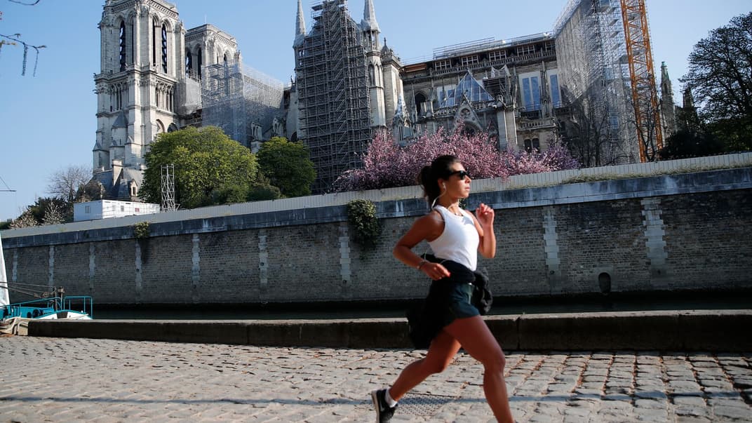 Дівчина пробігає повз залишки Нотр-Даму в Парижі, Франція. 15 квітня 2021 року