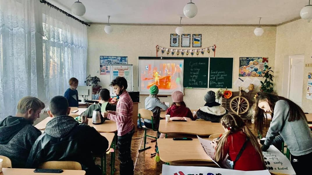 Учні школи у Трьохізбенці на Луганщині слухають урок, який викладає волонтерка