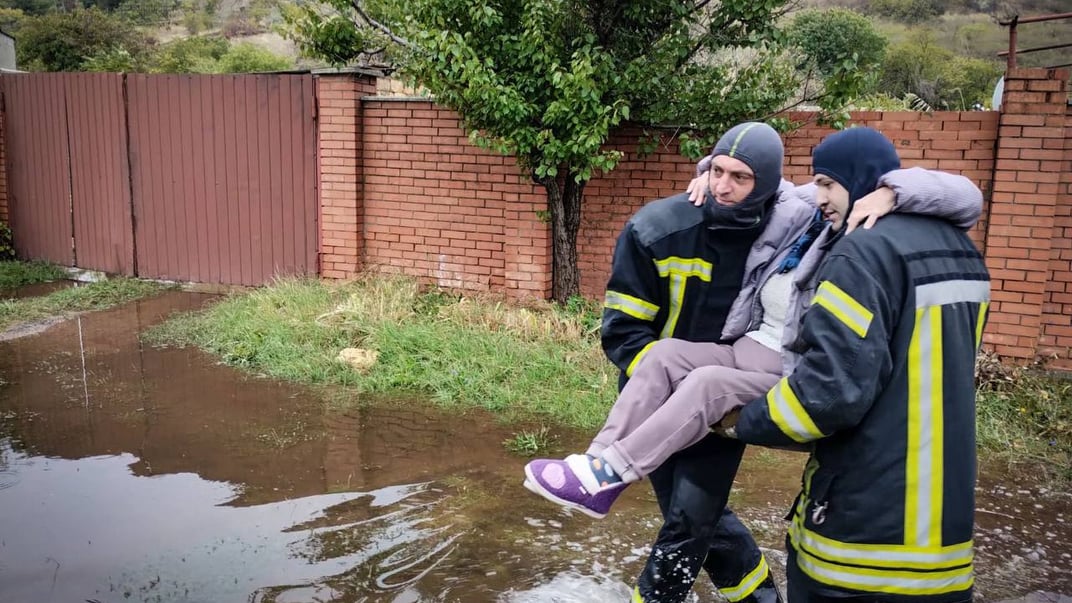 Рятувальники виносять жінку після негоди в Одесі