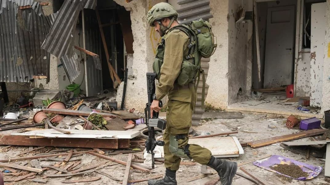 Ізраїльський солдат проходить повз будинок, пошкоджений унаслідок атаки ХАМАСу, в кібуці Кфар-Аза, Ізраїль, 27 жовтня 2023 року