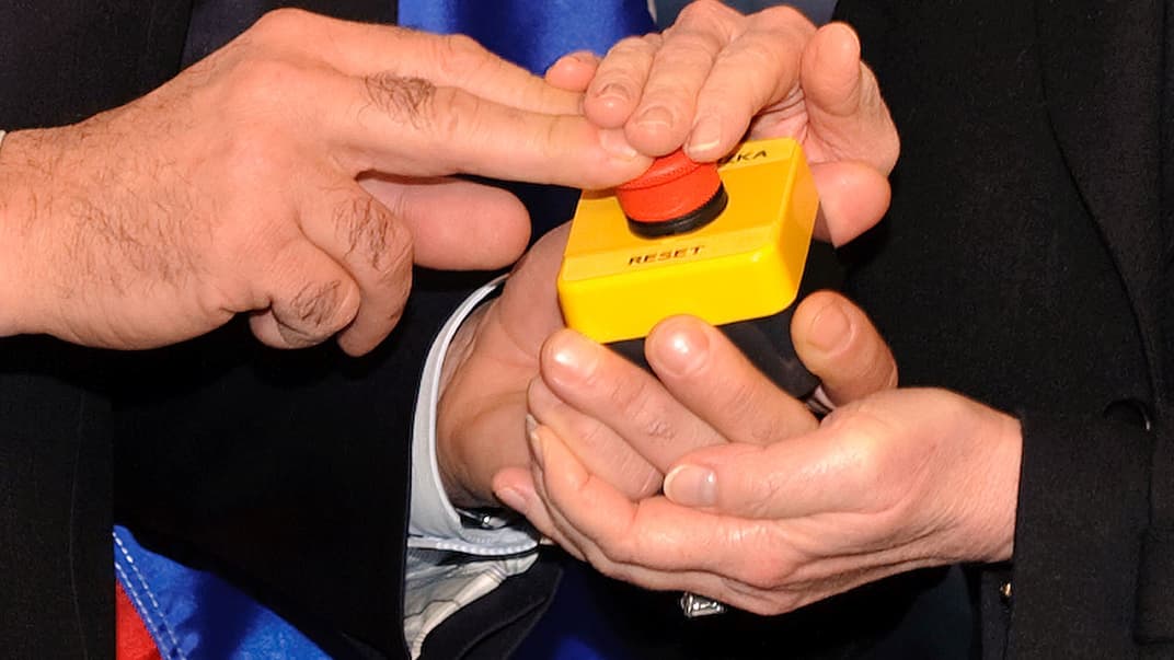 Символічна кнопка «перезавантаження» відносин, яку державна секретарка США Гіларі Клінтон подарувала міністру закордонних справ РФ Сергію Лаврову під час зустрічі в Женеві, Швейцарія, 6 березня 2009 року. На ній російською написано «перегрузка» (замість «перезагрузка»)