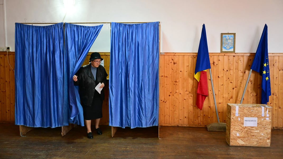 Жінка виходить із кабінки, щоб проголосувати на виборчій дільниці в Першані під час другого туру президентських виборів у Румунії, 18 травня 2025 року