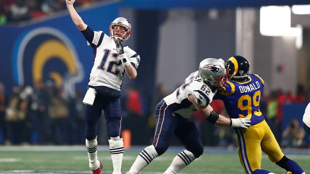 Квотербек команди New England Patriots Том Бреді (ліворуч) із м'ячем у другій половині матчу суперфіналу НФЛ між Los Angeles Rams та New England Patriots на стадіоні в Атланті, штат Джорджія, США, 3 лютого 2019 року. «Патріоти» виграли у «Ремз» із рахунком 3-13.