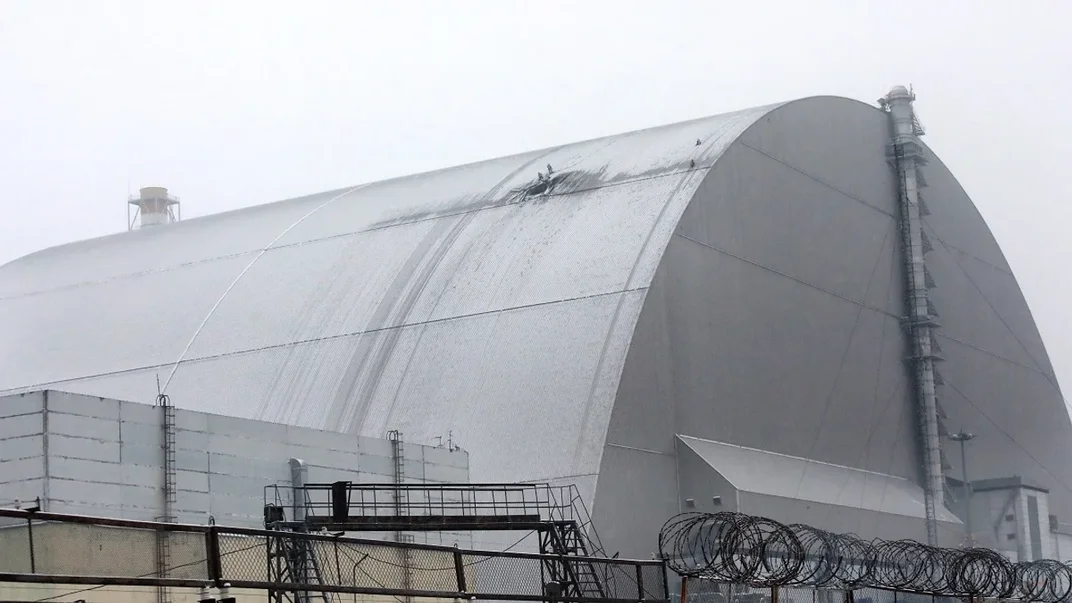 Українські рятувальники працюють на місці влучання російського безпілотника в Новий безпечний конфайнмент на Чорнобильській АЕС