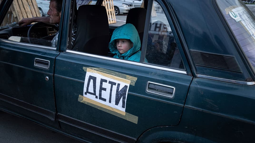 Дівчинка сидить у машині після прибуття з Токмака до центру для вимушених переселенців у Запоріжжі, 2 травня 2022 року