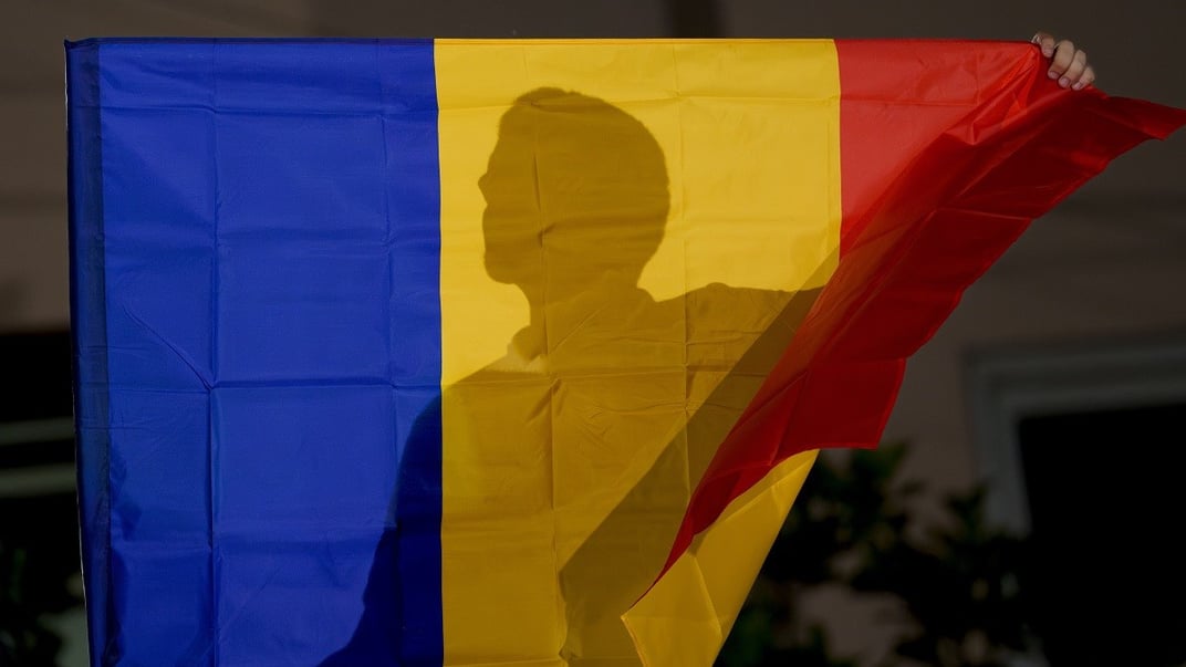 Ілюстративне фото. Прихильник правої партії «Альянс за єдність румунів» (AUR) тримає державний прапор після оголошення екзит-полів на виборах до Європейського парламенту в Бухаресті, 9 червня 2024 року