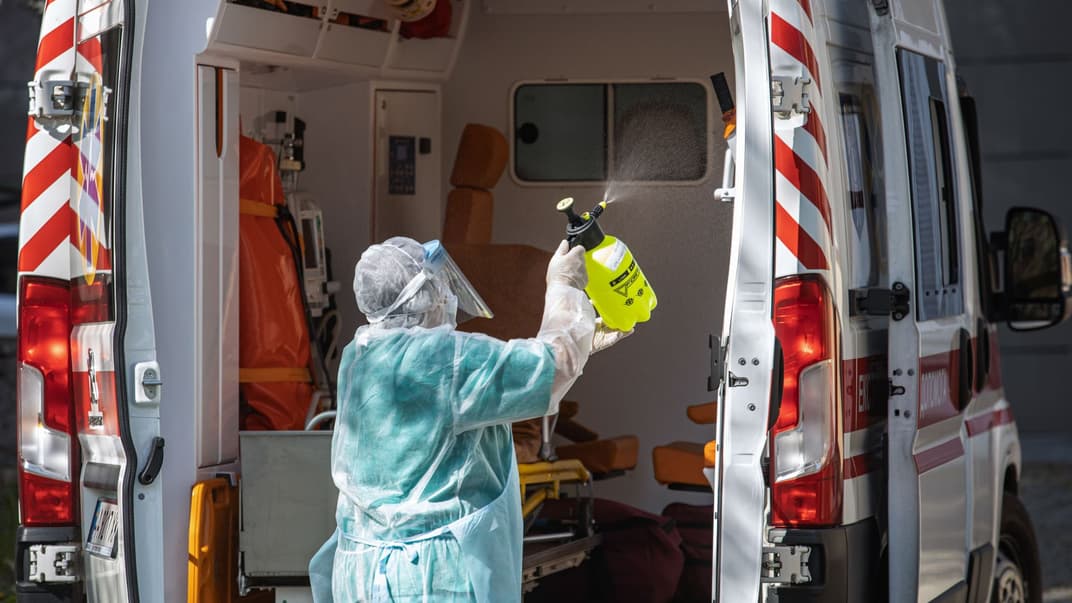Медицинский работник дезинфицирует машину скорой помощи, которая доставила пациента с подозрением на COVID-19 в Александровскую больницу в Киеве