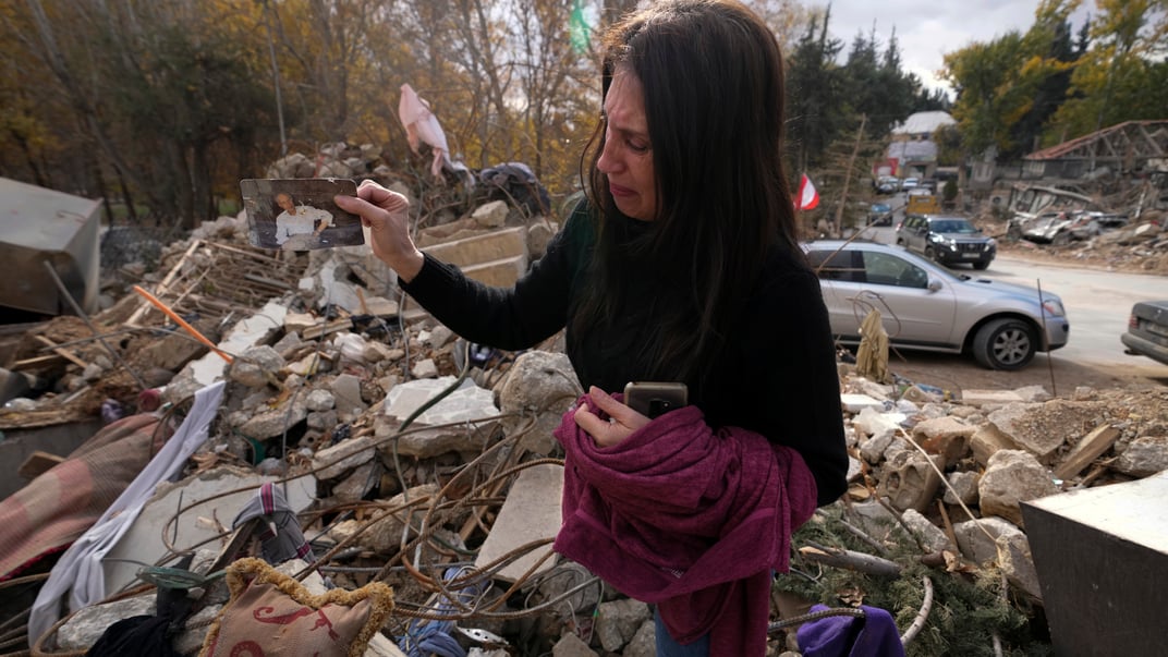 Ливанка Зейна Рида Джавхари показывает фото своего отца, которое нашла под обломками своего разрушенного дома в Баальбеке, восточный Ливан, 28 ноября 2024 года