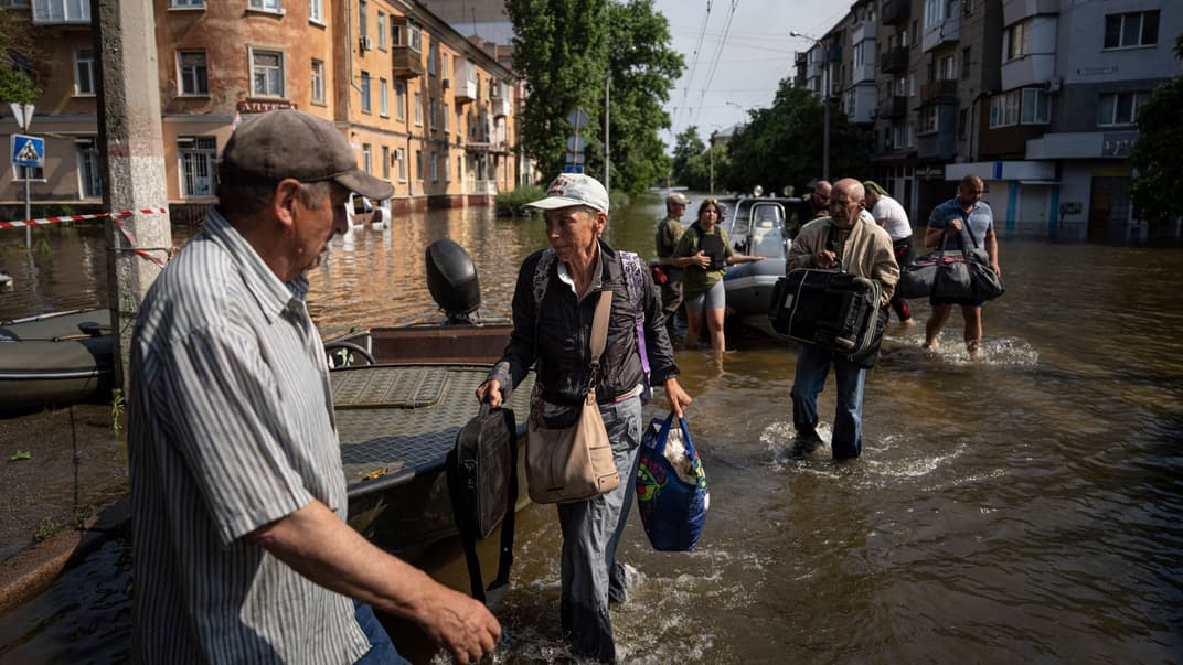 Жінка несе сумки після евакуації із села Кардашинка на лівому березі річки Дніпро в Херсоні, 9 червня 2023 року