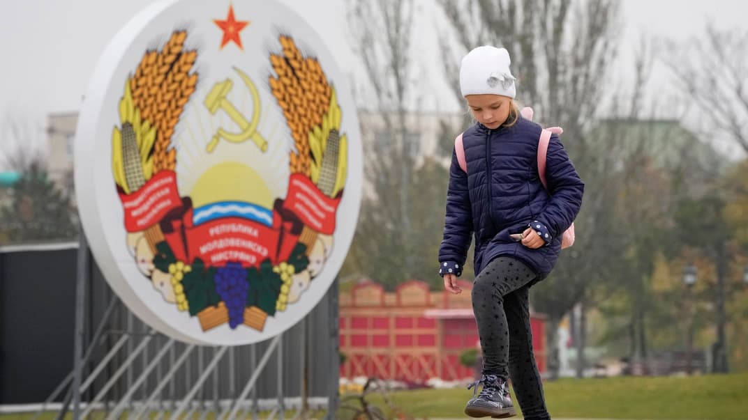 Девочка проходит мимо герба «Приднестровье» в Тирасполе, Молдова, 1 ноября 2021 года