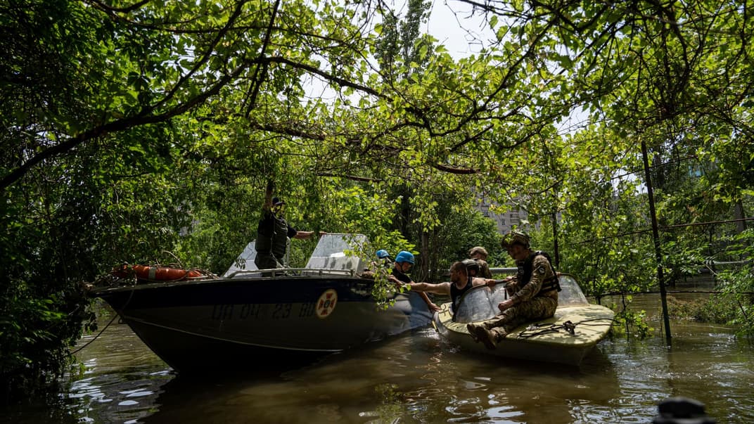 Рятувальники та українські військовослужбовці керують човнами для евакуації людей із затопленого району в Херсоні, 8 червня 2023 року