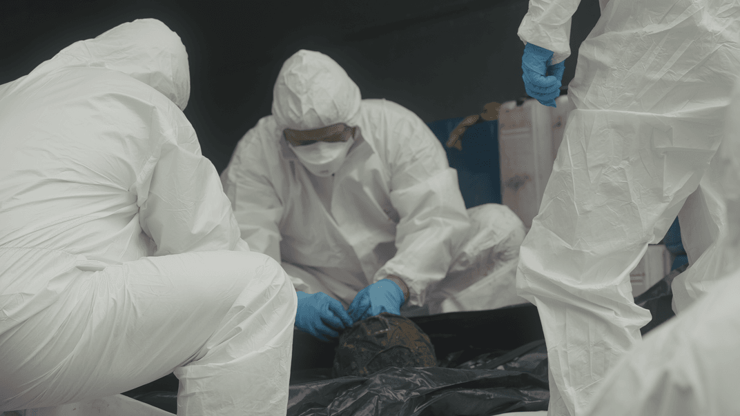 Фахівці оглядають тіла загиблих у рефрижераторі перед тим, як передати їх до моргу