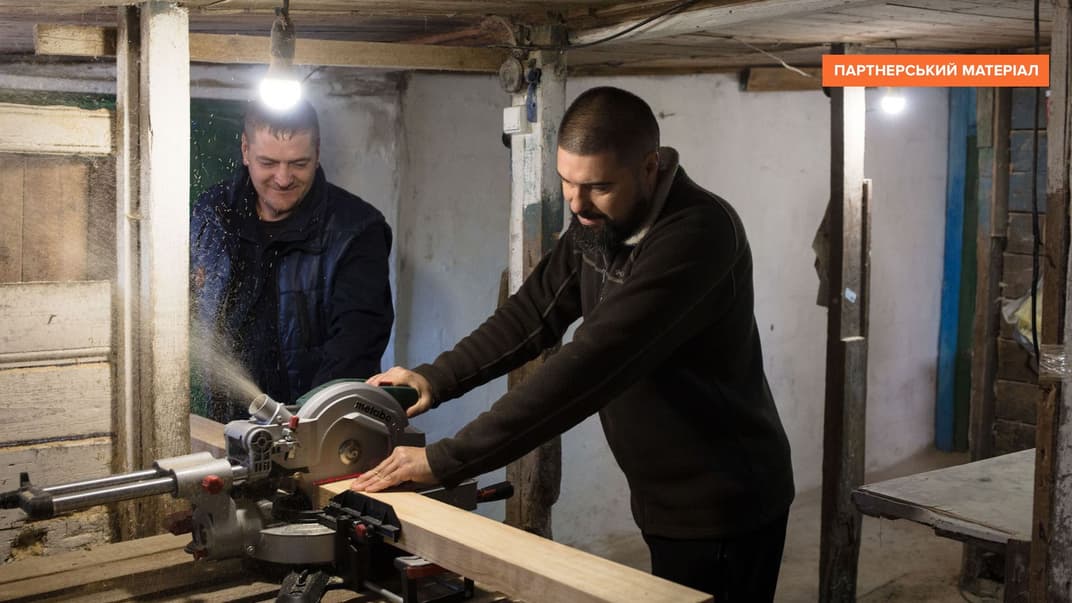 Ветерани В'ячеслав Правдивий і Сергій Коваль ріжуть дерев'яні бруски, виготовляючи ліжка на створеному ними підприємстві