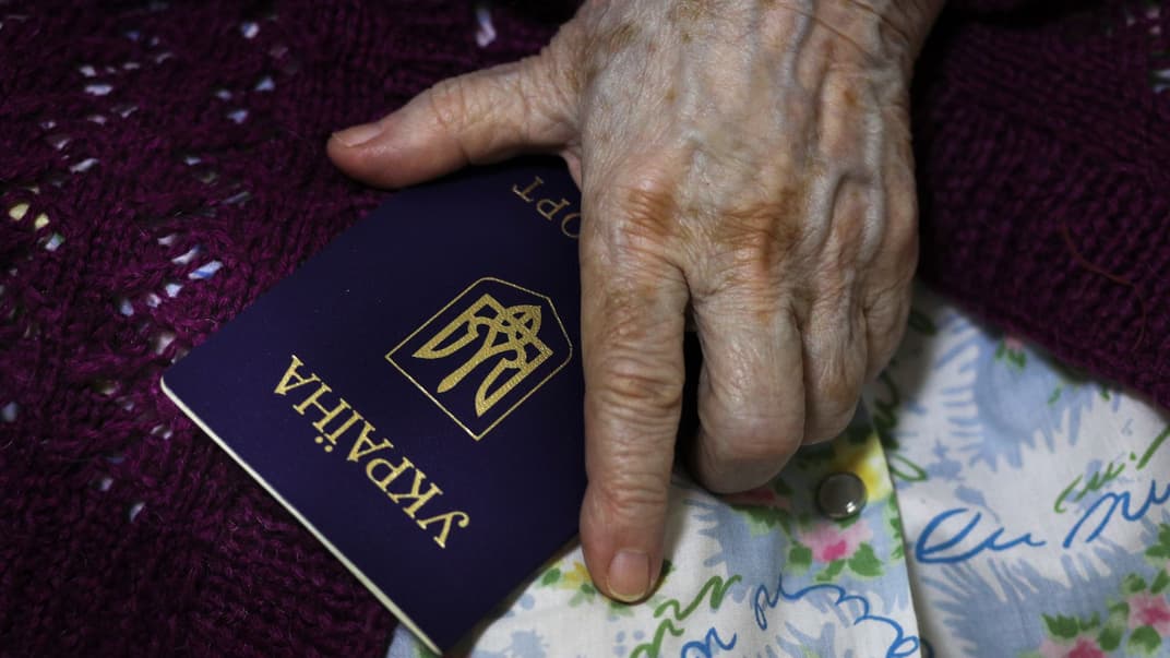 Пожилая женщина из оккупированной Луганской области держит украинский паспорт на «пункте голосования» на псевдореферендуме в Волгограде, россия, 23 сентября 2022 года