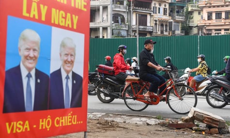 Чоловік проїжджає на велосипеді повз рекламний стенд із зображенням президента США Дональда Трампа в Ханої, 24 листопада 2020 року