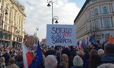 Протестувальники тримають плакат із надписом «Це вето тхне російською шкарпеткою», Варшава, Польща, 15 березня 2026 року
