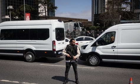 Поліціянт стоїть біля огородженої зони будівлі ізраїльського консульства після стрілянини, Стамбул, Туреччина, 7 квітня 2026 року
