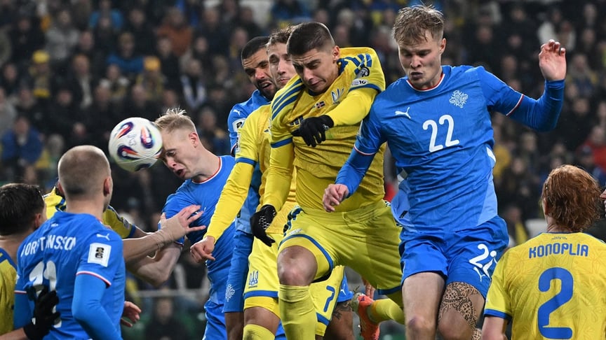 Захисник збірної України Віталій Миколенко (у центрі) та нападник збірної Ісландії Андрі Гудйонсен (спереду) змагаються за м’яч під час матчу групи D кваліфікації ЧС-2026 року