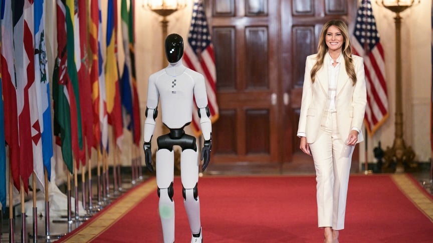 Перша леді США Меланія Трамп іду поруч із роботом-гуманоїдом до Східної кімнати Білого дому у Вашингтоні, округ Колумбія, 25 березня 2026 року