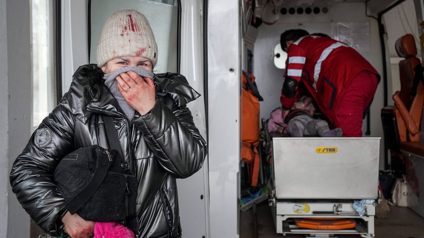 Женщина плачет, когда парамедики делают реанимацию пострадавшей во время обстрела девочки в городской больнице Мариуполя, 27 февраля 2022 года. Девочка не выжила
