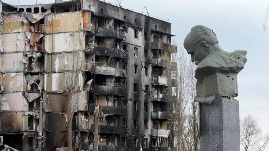 Пам'ятник Тарасу Шевченку на тлі зруйнованого під час російського обстрілу житлового будинку на центральній площі Бородянки, 6 квітня 2022 року