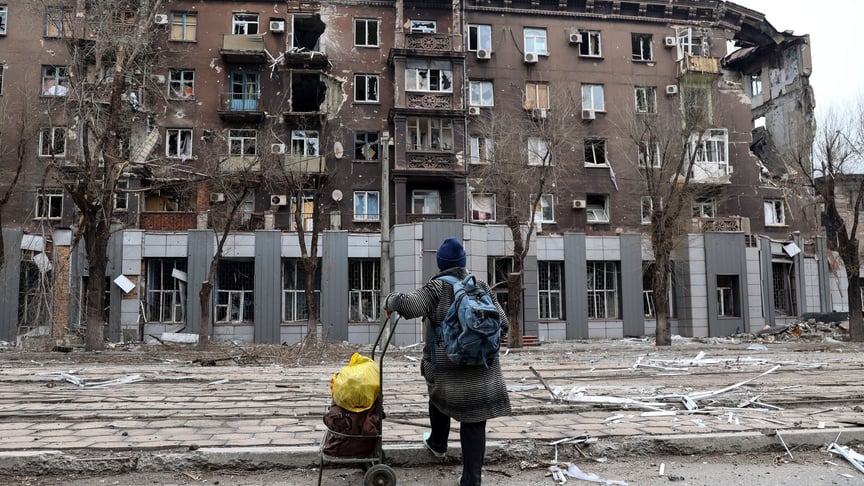 Місцева жителька дивиться на пошкоджений під час важких боїв житловий будинок поблизу металургійного комбінату імені Ілліча, Маріуполь, 16 квітня 2022 року
