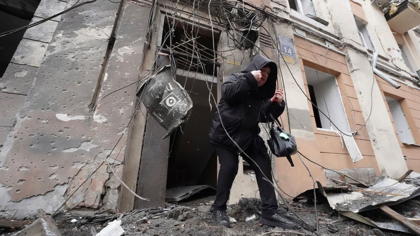 A woman leaves a residential building destroyed by a Russian missile in the center of Kharkiv, February 5, 2023