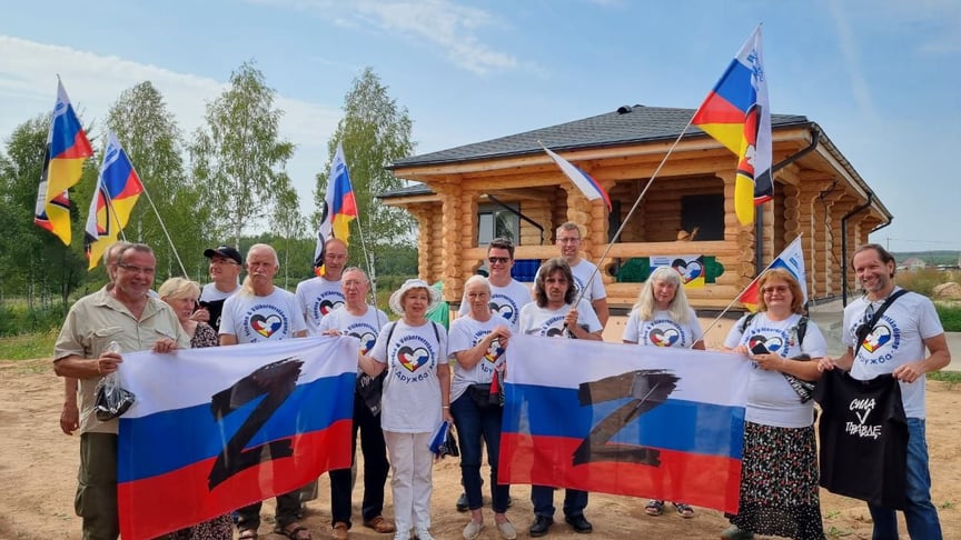 Фото, на якому працівник компанії позує разом з членами руху «Дружба» у 2022 році