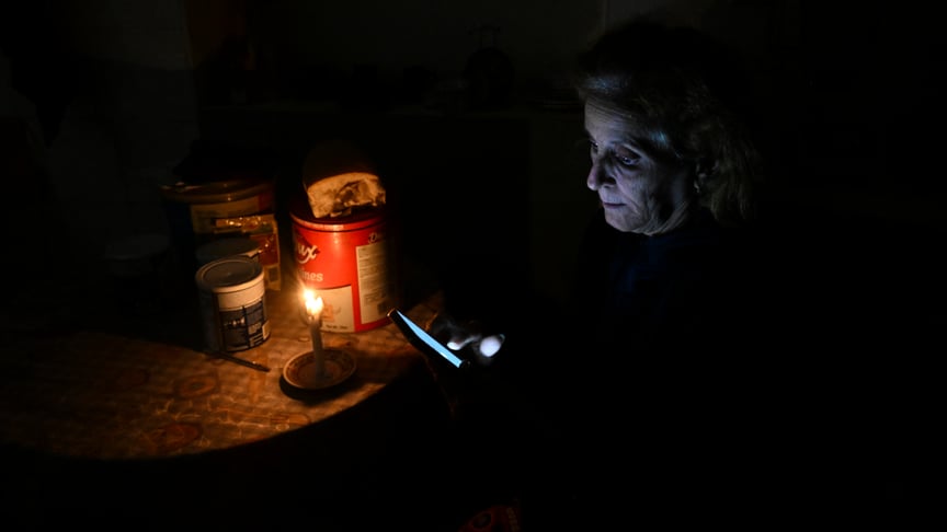 Ілюстративне фото. Жінка перевіряє свій мобільний телефон під час відключення електроенергії в районі Луяно в Гавані, 28 січня 2026 року