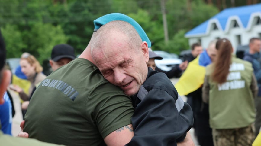 Український військовий, який повернувся з полону, обіймає морського піхотинця