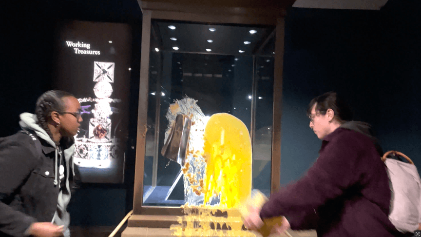 Протестувальники групи Take Back Power закидають їжею вітрину з королівськими коштовностями в Лондонському Тауері