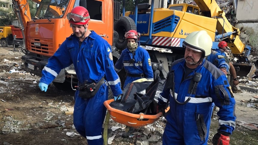 Рятувальники несуть загиблу людину на місці російського удару в Києві